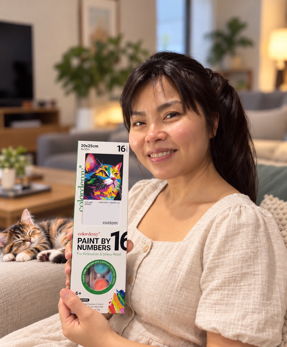 Someone holding their custom portrait kit, with their cat asleep beside them